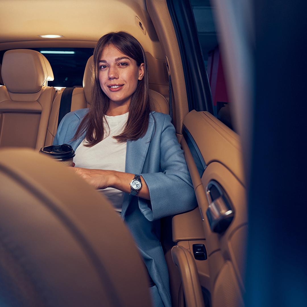 Professional woman relaxing in the backseat of a luxury limo for a night out in San Jose.